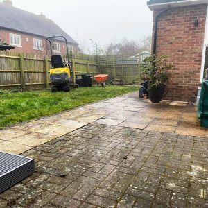 Mini excavator removing lawn area in preparation for levelling